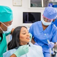 An African woman during a dental visit receives a dental cleaning